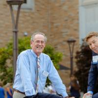 Two guests outside posing for a photo while standing by a ledge.